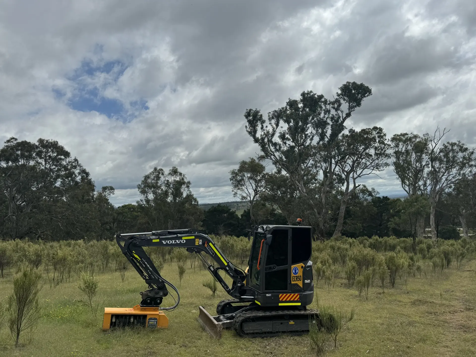 Two mini excavators on a grass paddock
