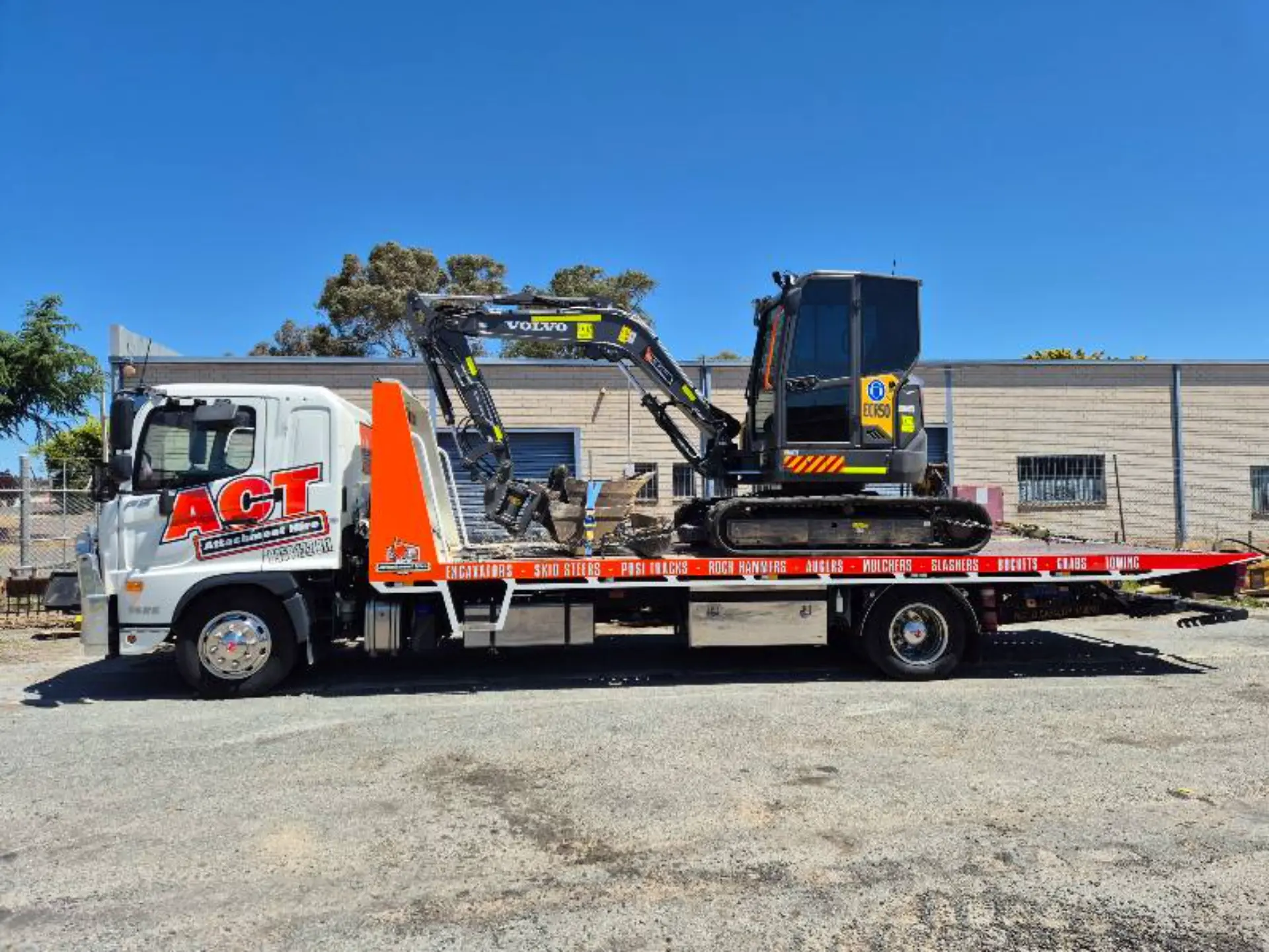 ACT Attachment Hire flatbed truck with an excavator loaded