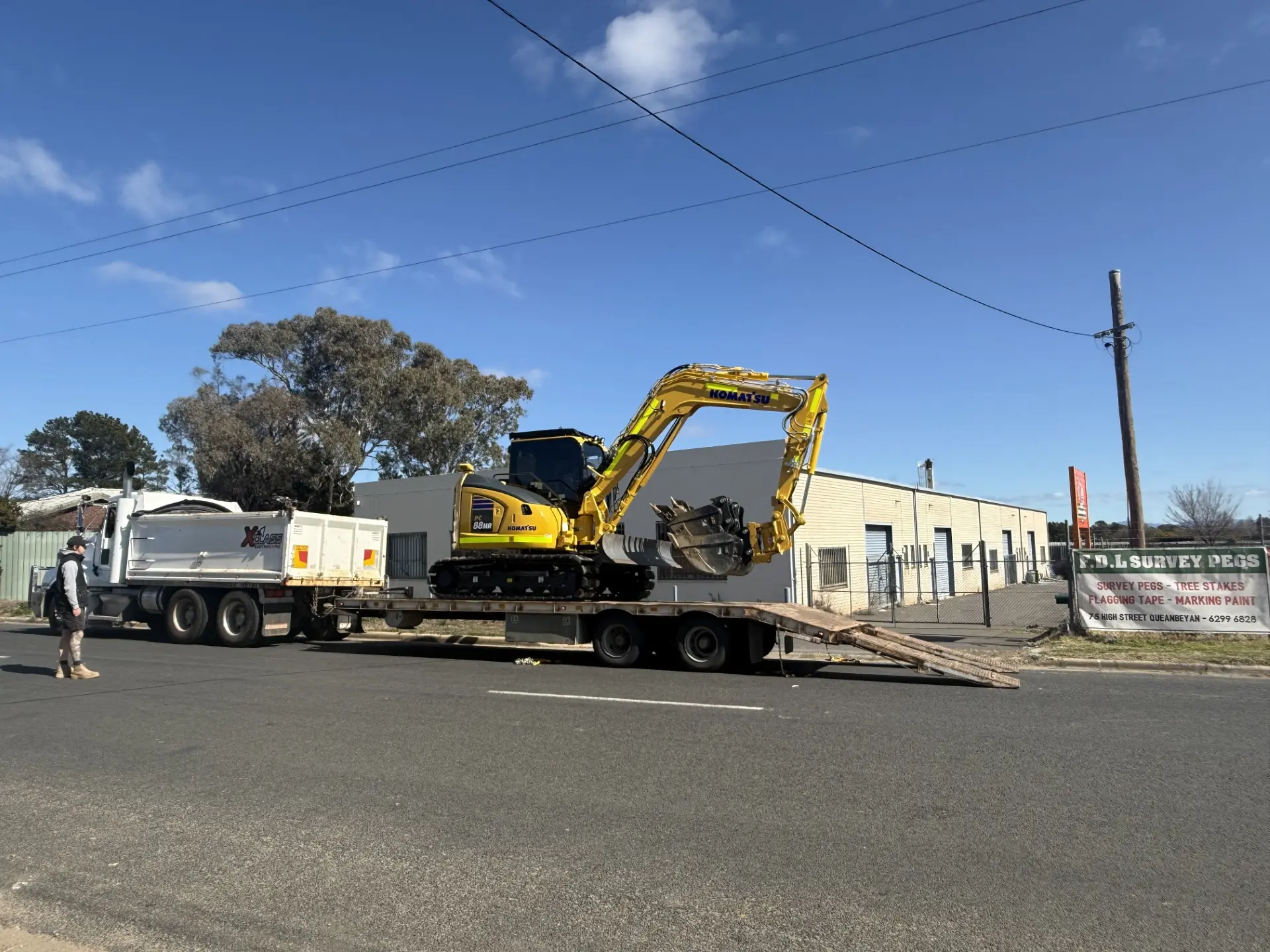 Mini excavator loaded on a flatbed, roadside