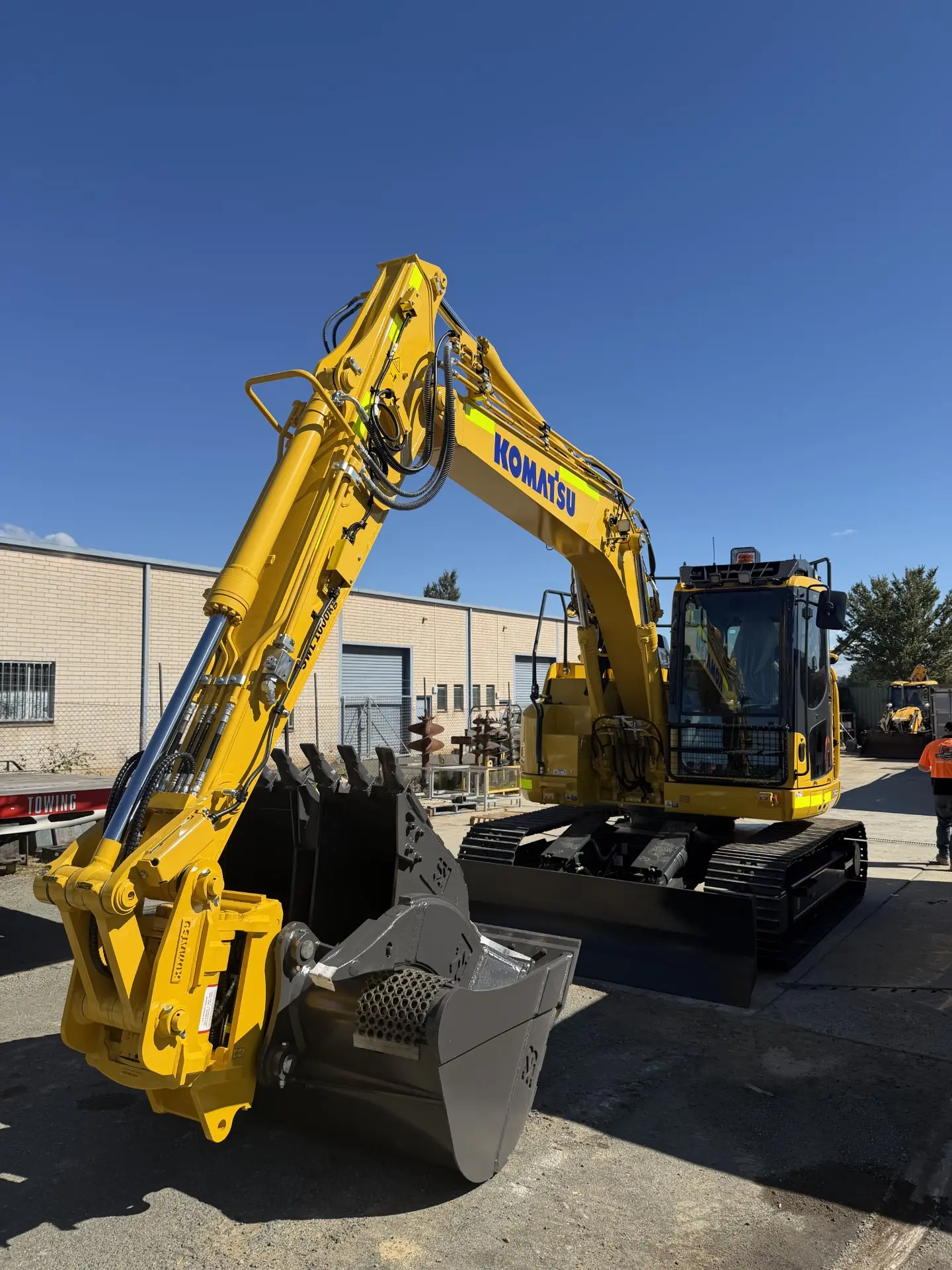 Excavator with bucket lowered in the yard