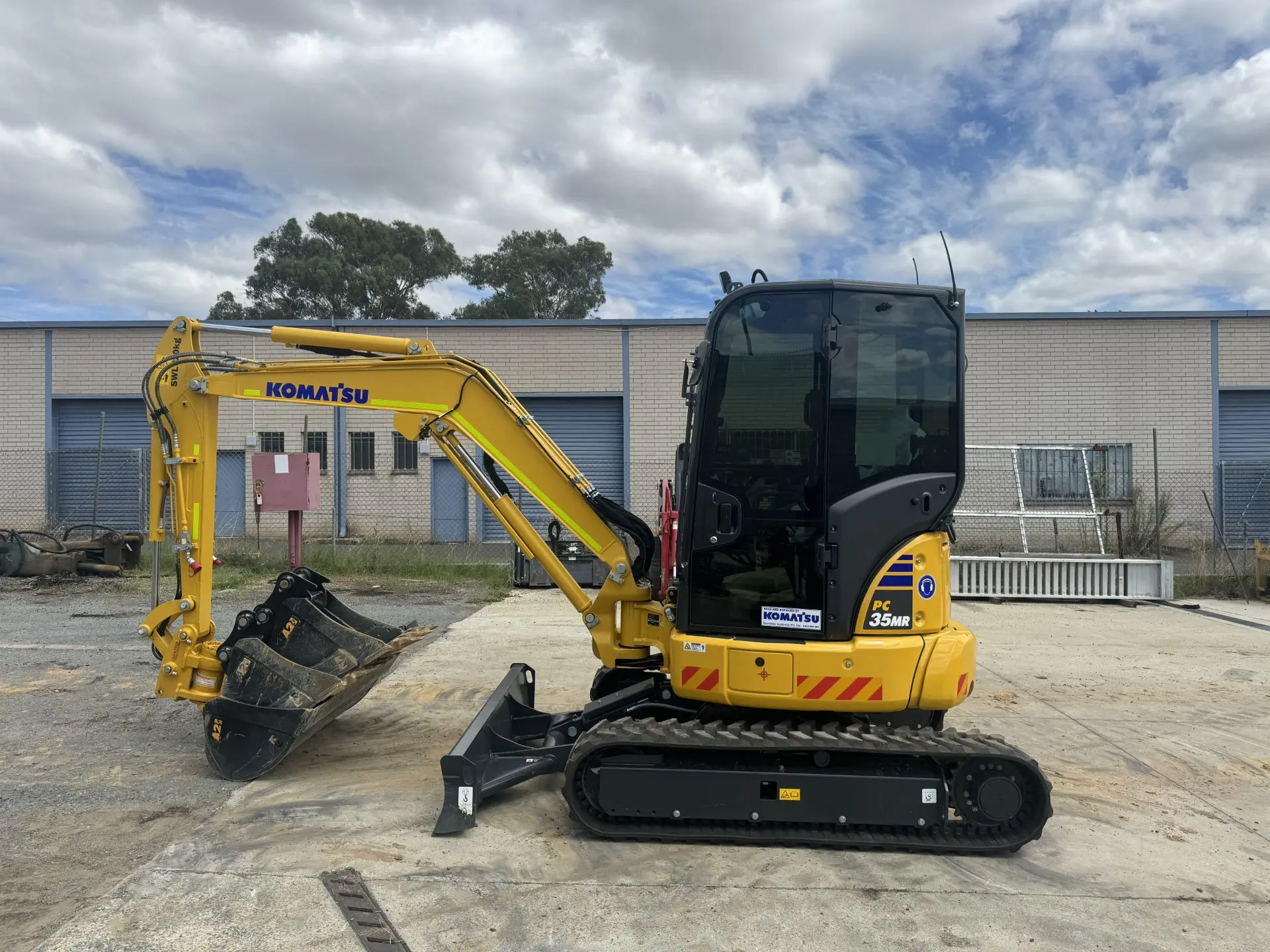 Excavator with bucket attachment in the warehouse