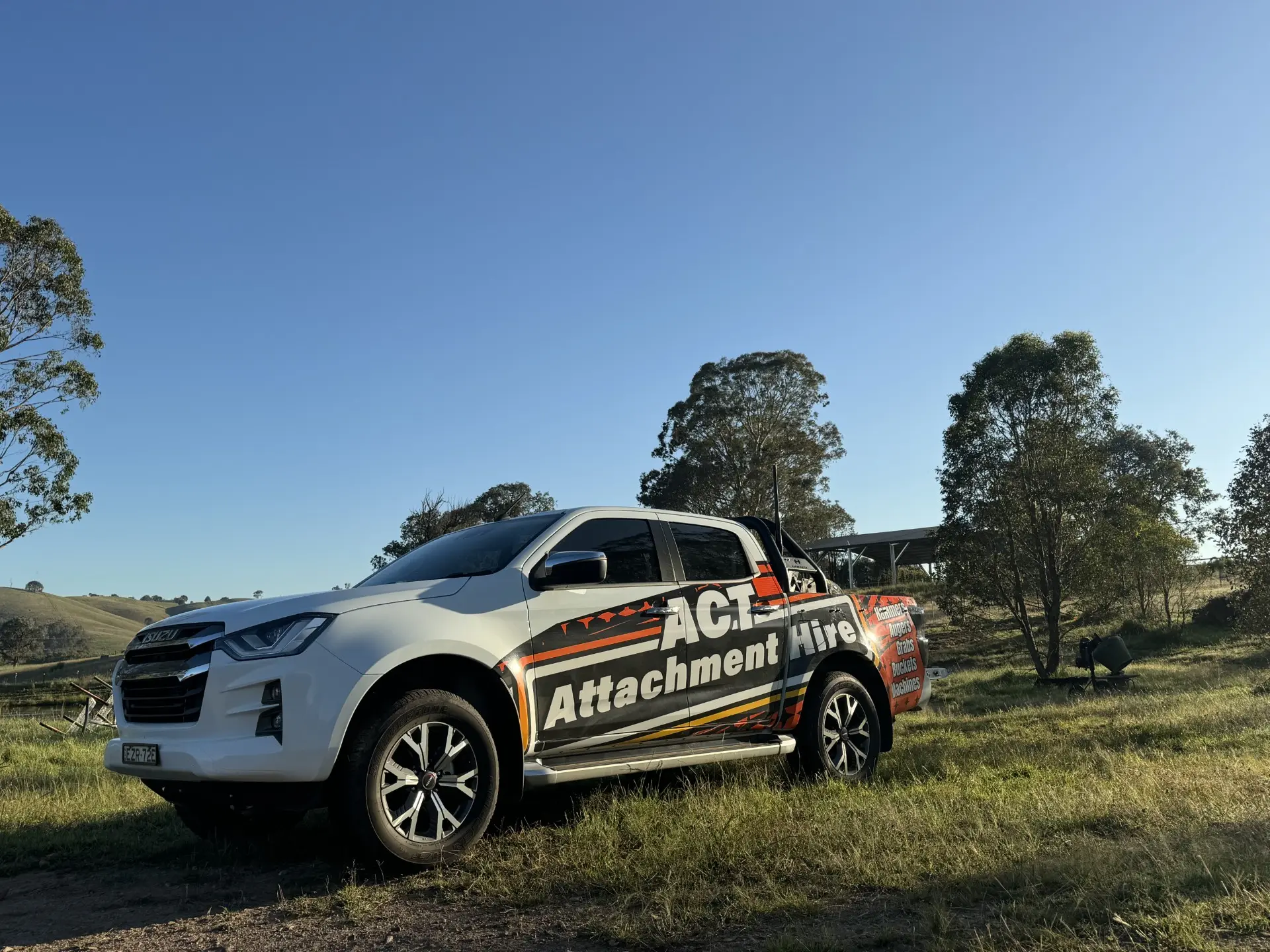 Branded ACT Attachment Hire ute parked on a bushland block