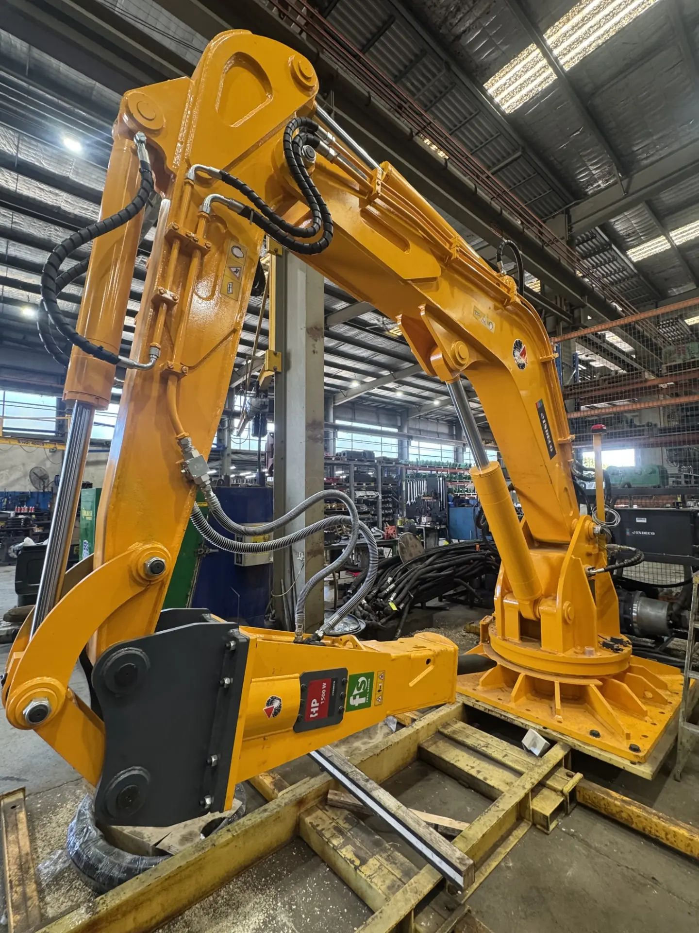 Close-up of an excavator arm fitted with an attachment in the warehouse