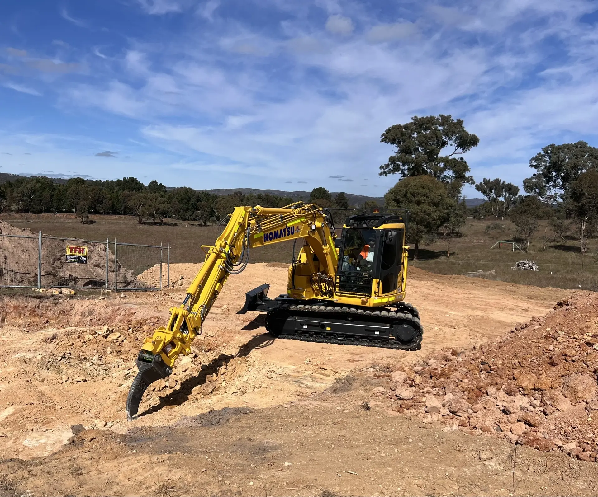 Excavator fitted with a grab attachment clearing a bushland site