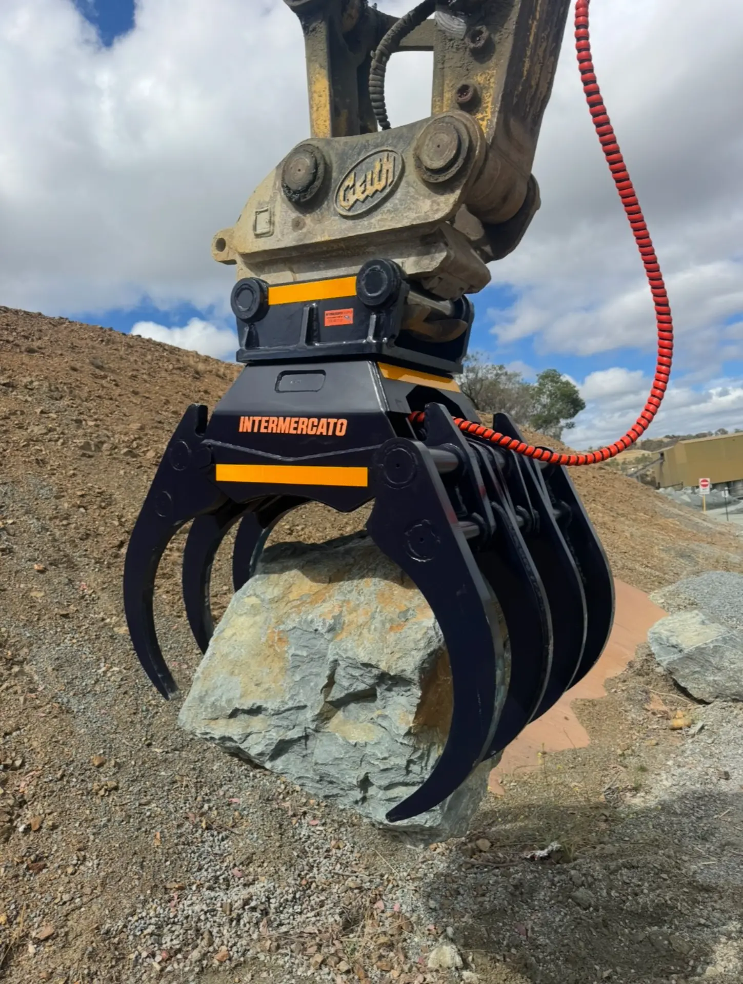 Rock grapple attachment gripping a large rock