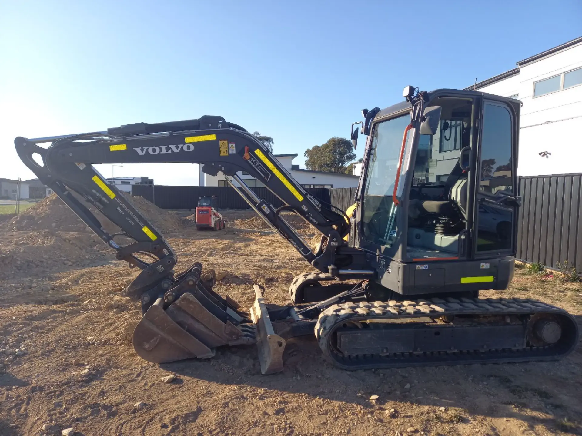 Two Volvo excavators digging in a yard