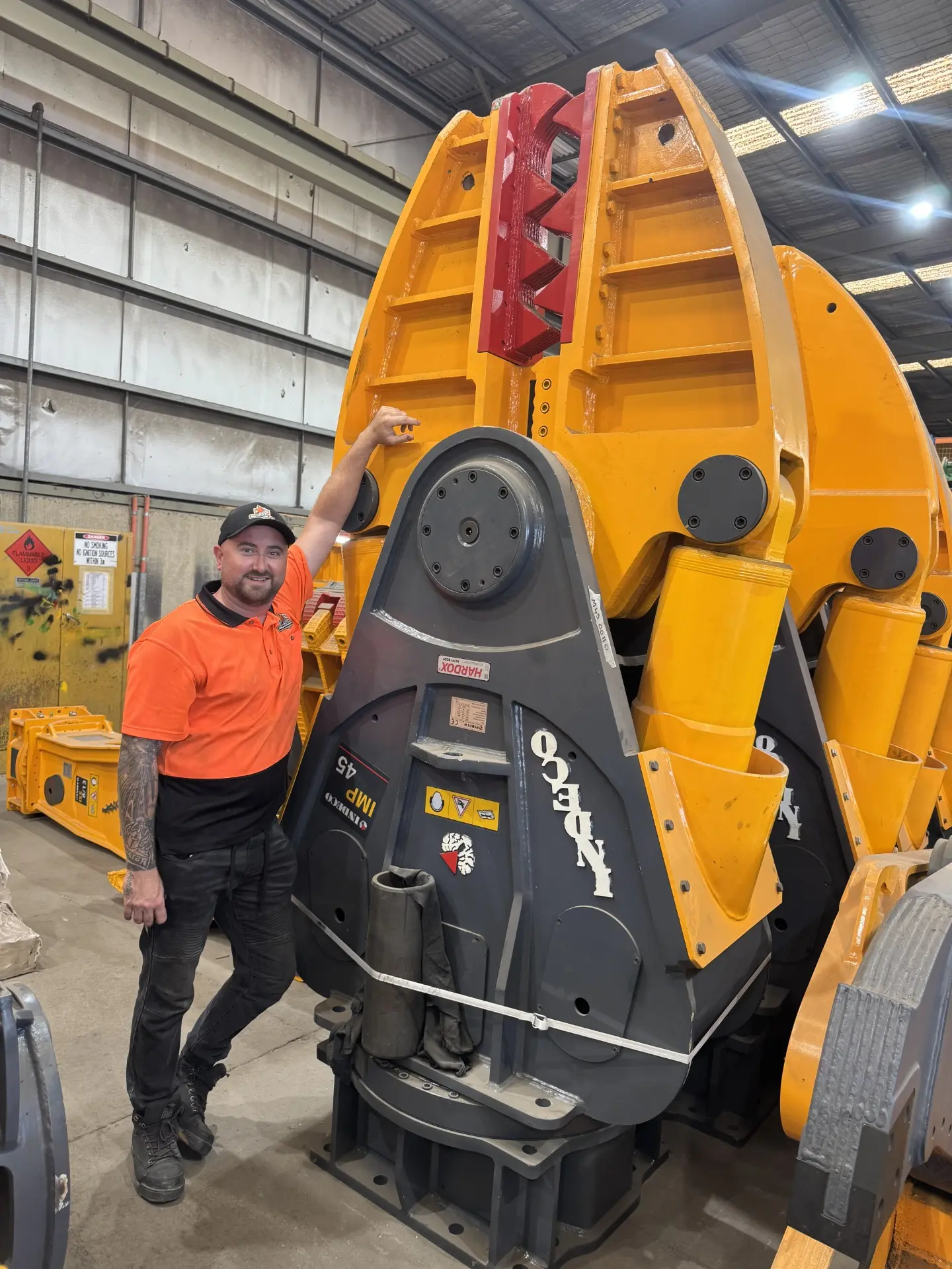 ACT Attachment Hire team member with a heavy demolition attachment in the workshop